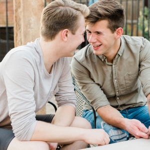 Two men looking at each other and smiling illustration lgbtq youth overcoming bullying and harassment.